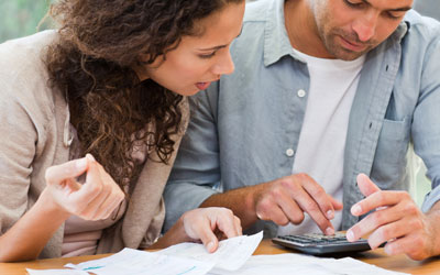 Couple using calculator and looking at bills