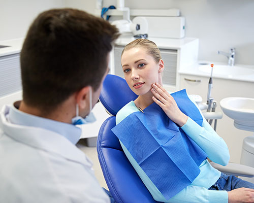 woman with toothache in dentist's chair