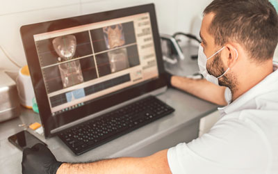 Dentist looking at digital X-rays of teeth