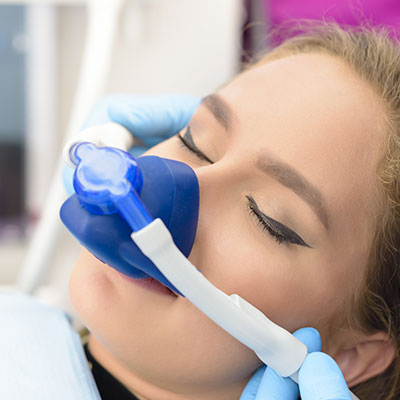 woman receiving laughing gas in dentist chair