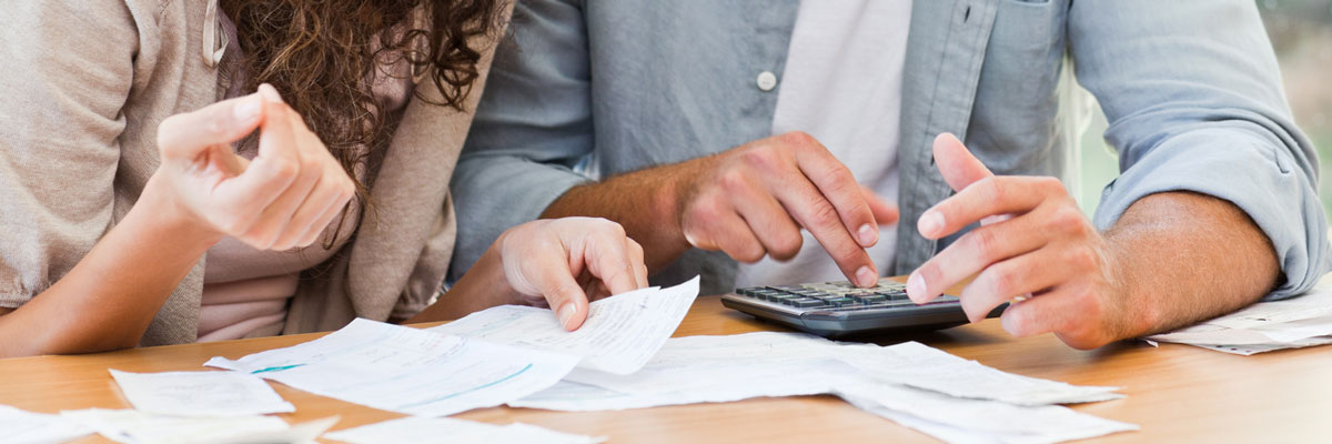Couple looking at bills and using calculator