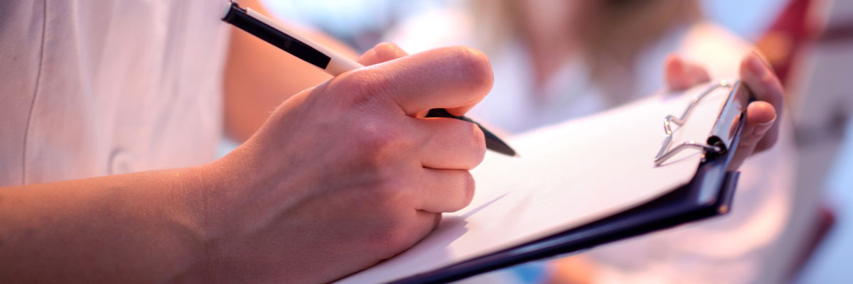 Close up of dentist filling out patient forms